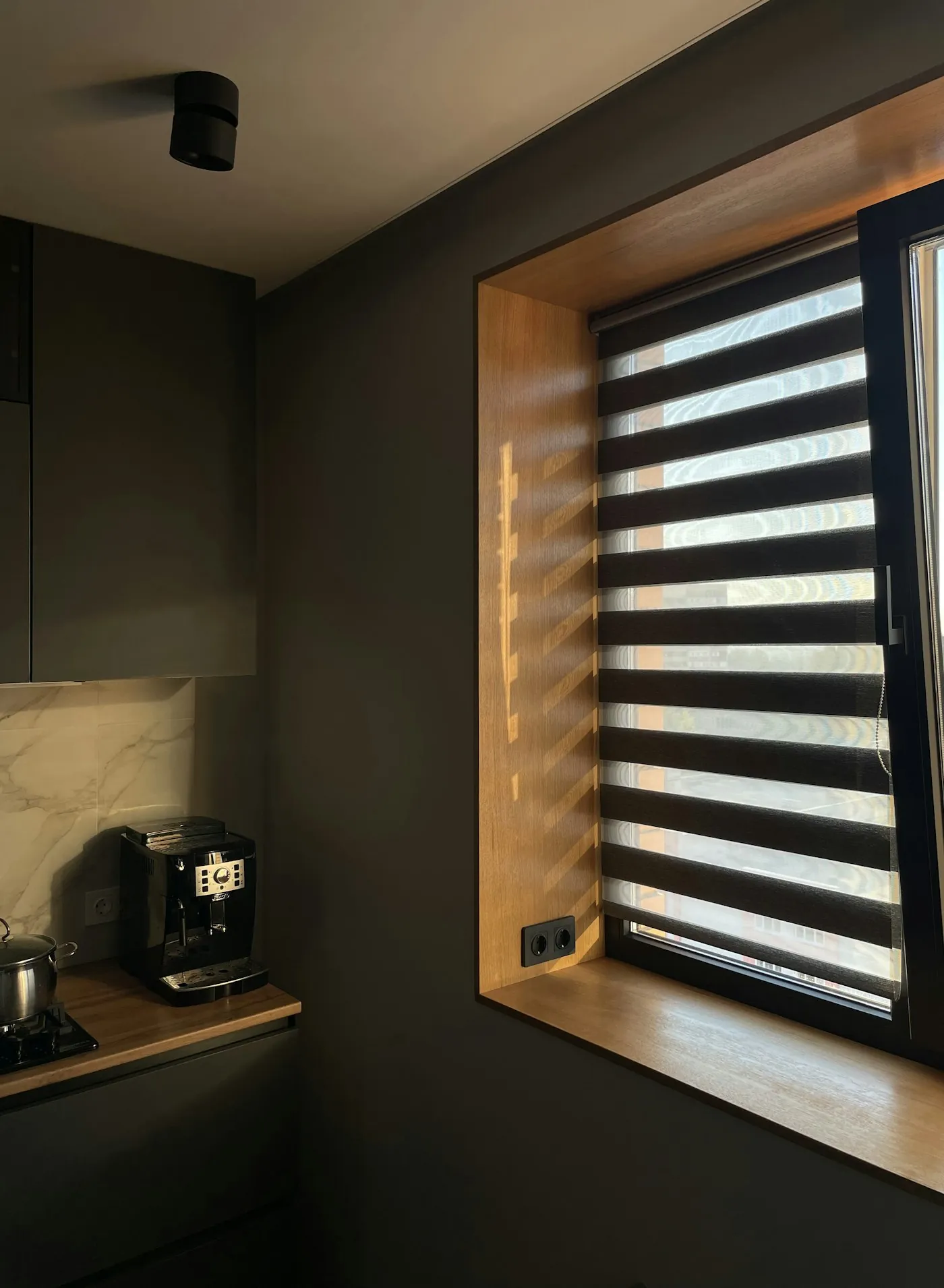 Sunlight filtering through slatted window blinds in a bright room