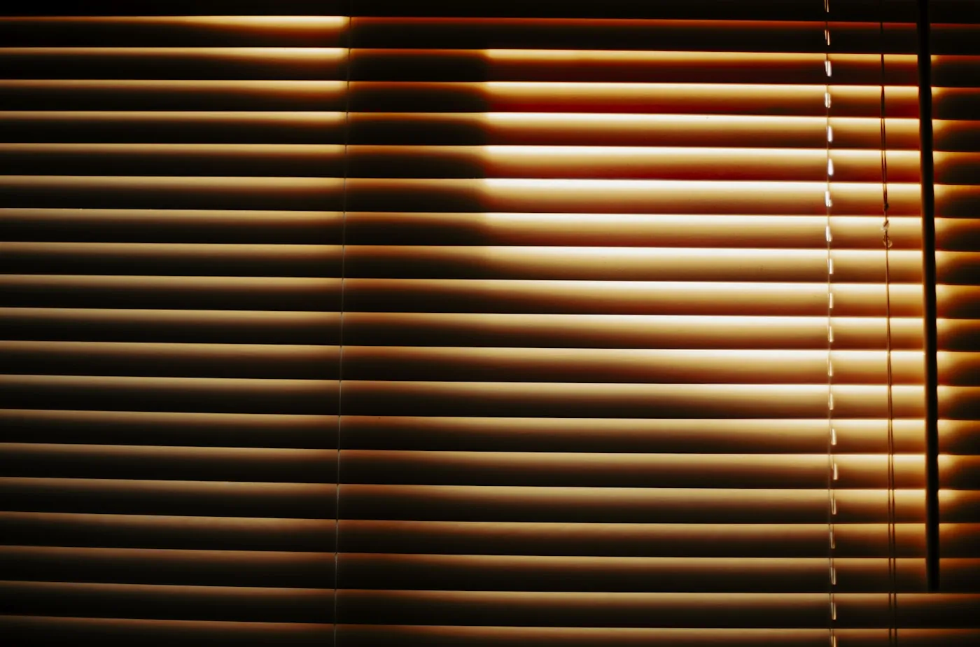 Wooden Venetian blinds filtering warm sunlight