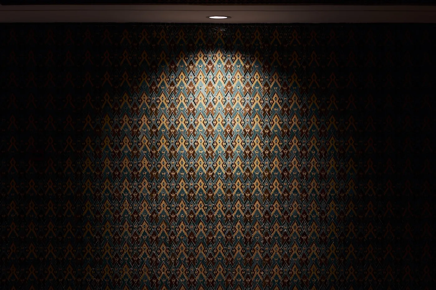 Dining room with a patterned feature wall and velvet chairs